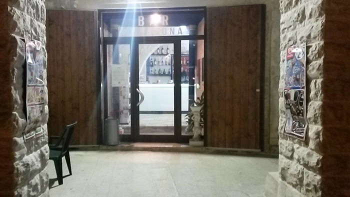L'ingresso di Bar D'Argona, su via Nazario Sauro. Sotto i portici, l'unica illuminazione garantita è quella delle attività commerciali. Malgrado il progetto lo preveda, la ditta appaltatrice non ha ancora predisposto l'illuminazione pubblica.
